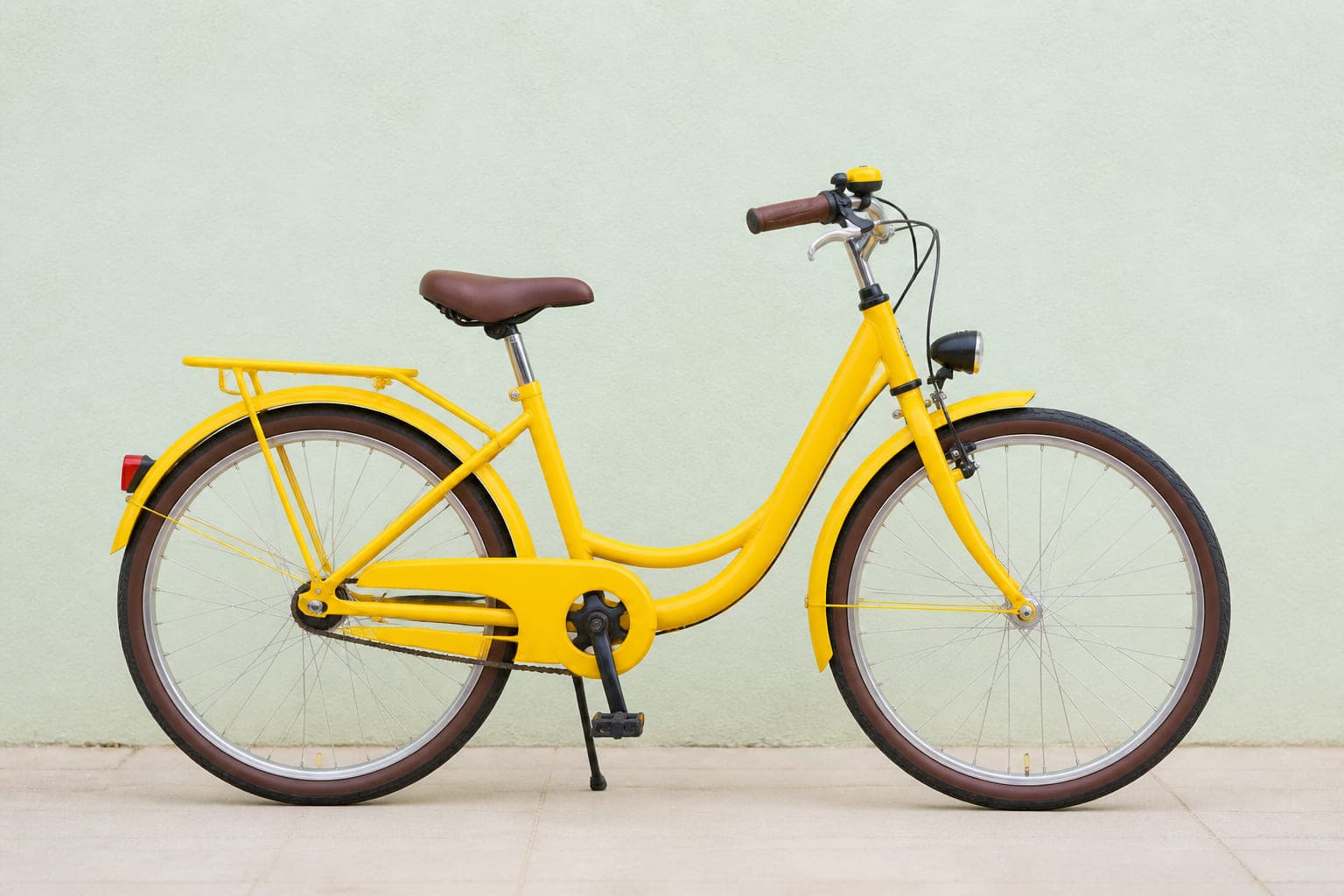 Kinderrad mit 24-Zoll-Laufrädern in Gelb, mit Schutzblechen, kleinem Gepäckträger und Licht, von der Seite